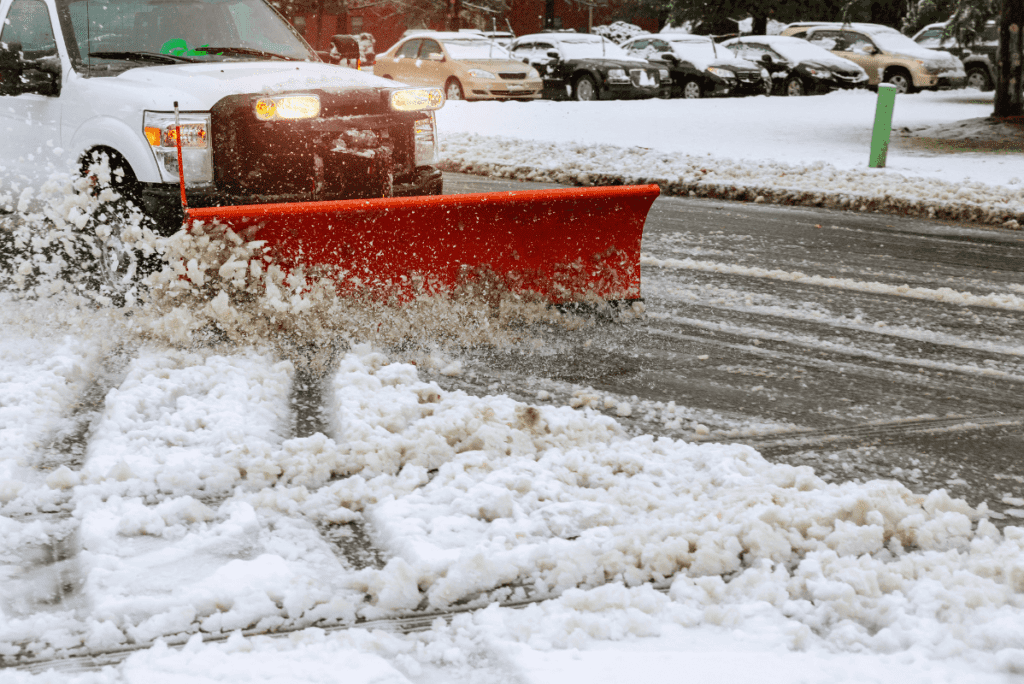 A plow truck clearing snow on a road