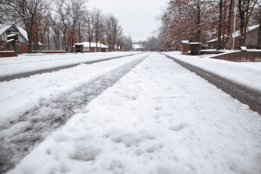 A snow covered road on a residential street