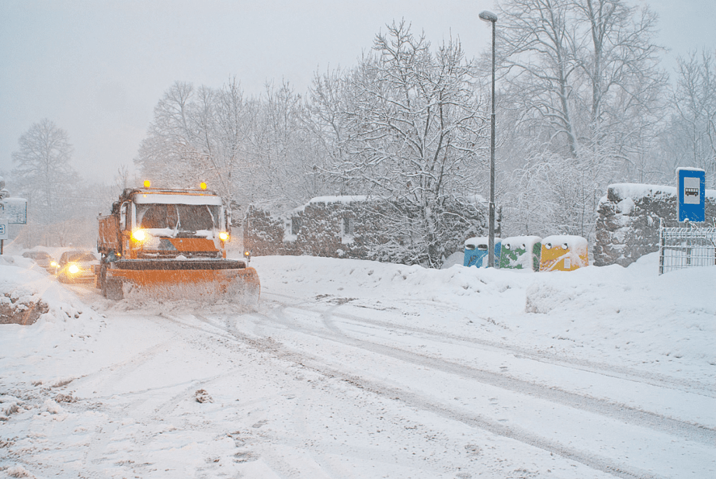 A truck plows a street in a snow storm