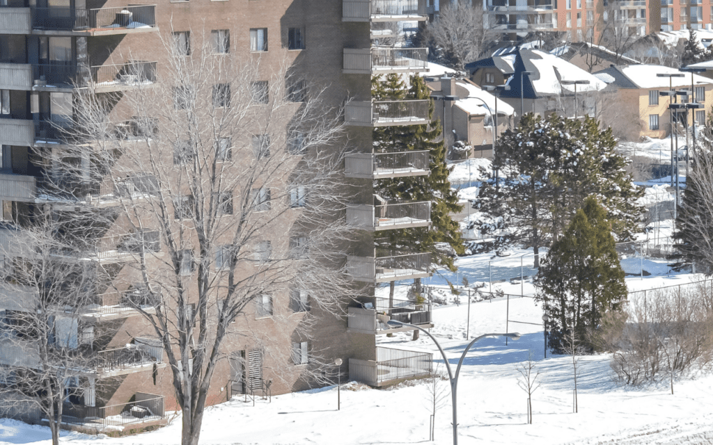 Condo buildings, trees, and streets covered ins snow