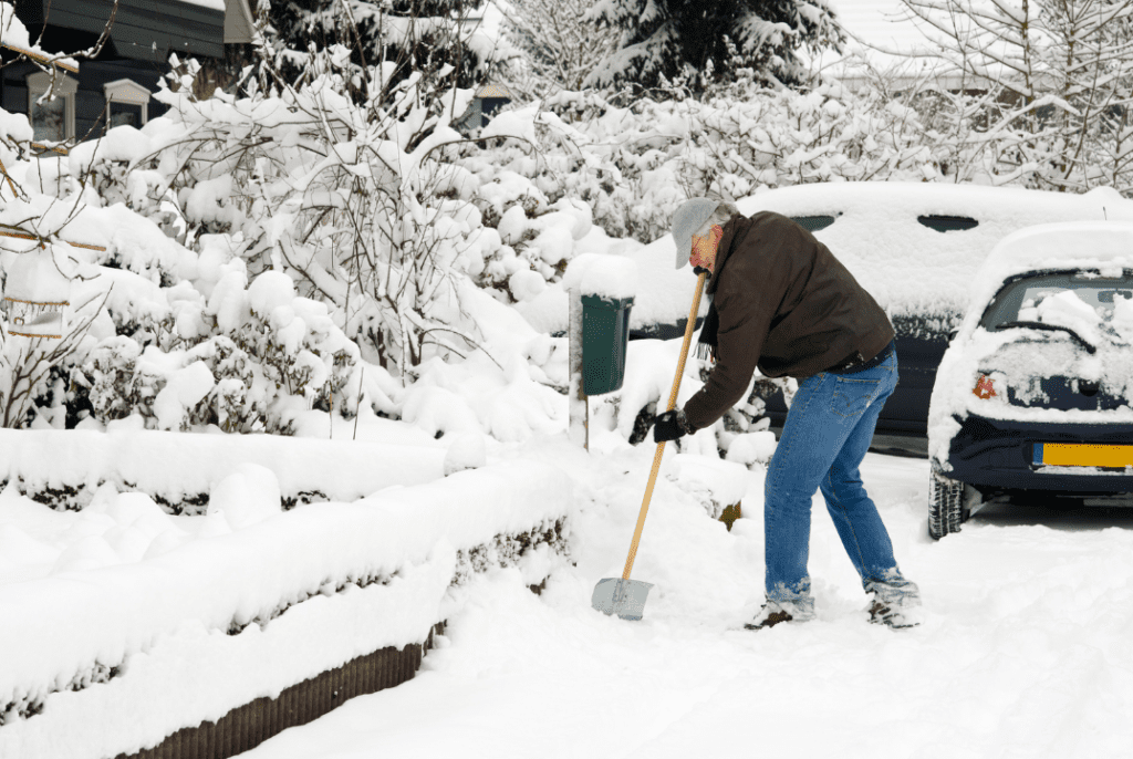 A man clearing out a thick pile of snow with a shovel