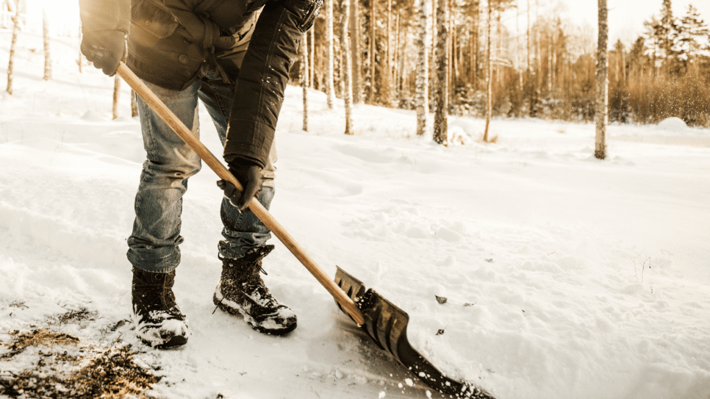 A man shoveling snow on a sunny morning
