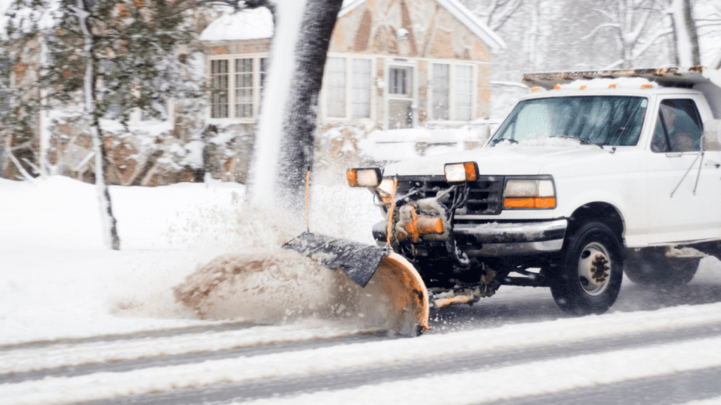 A plow truck clearing out snow from the street