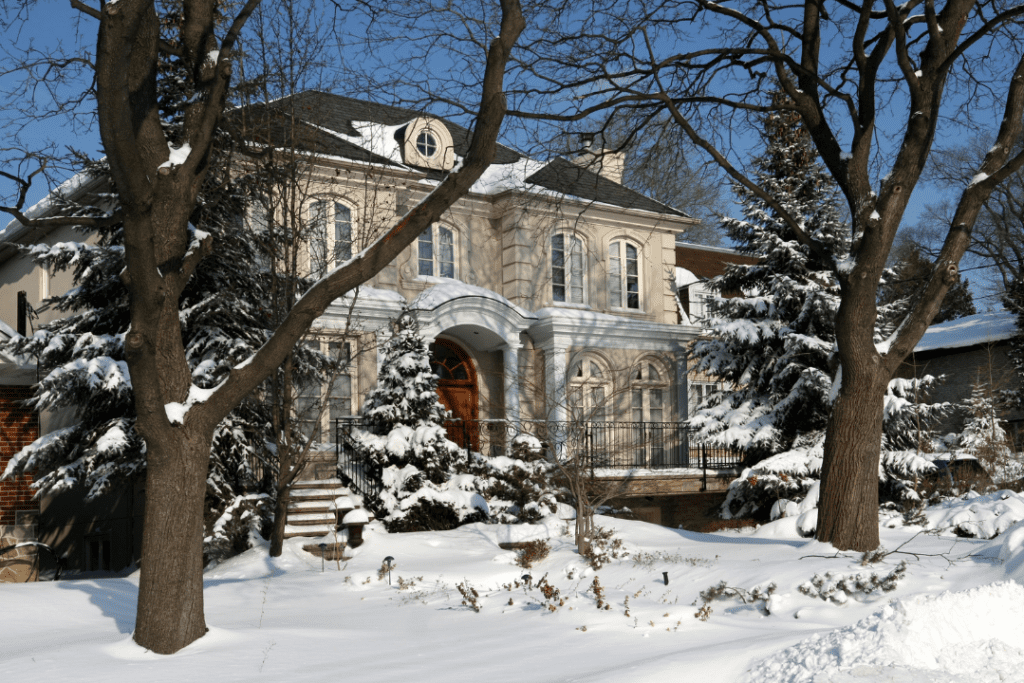 A large house and trees covered in snow