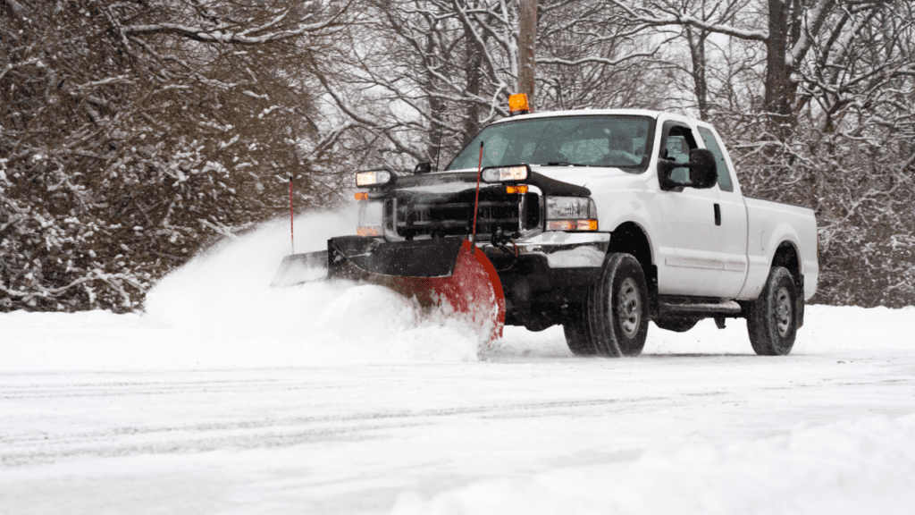 A snow plow clearing out snow on the streets