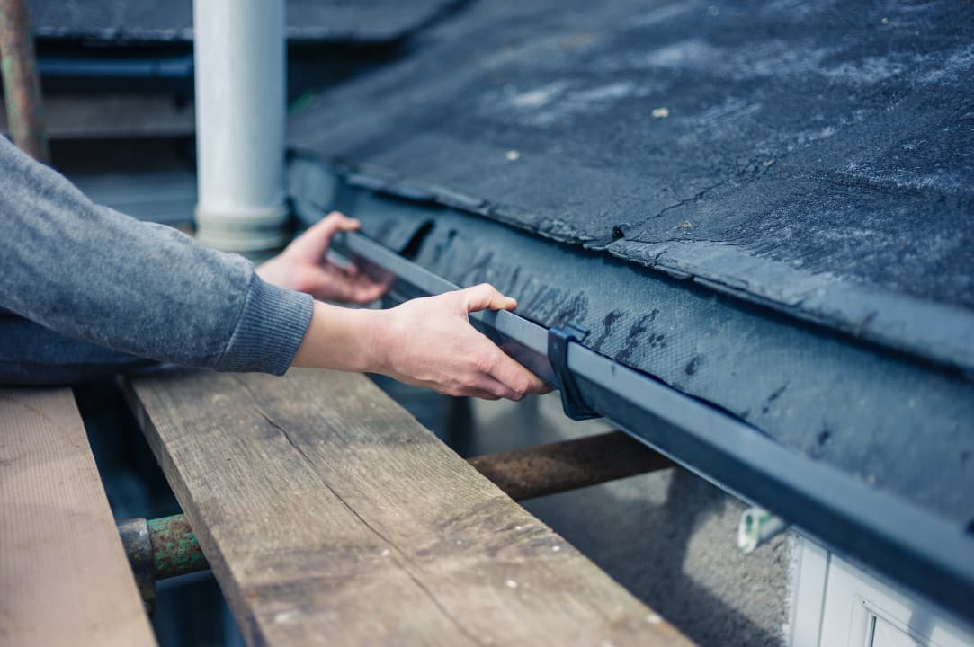 A person installing a gutter