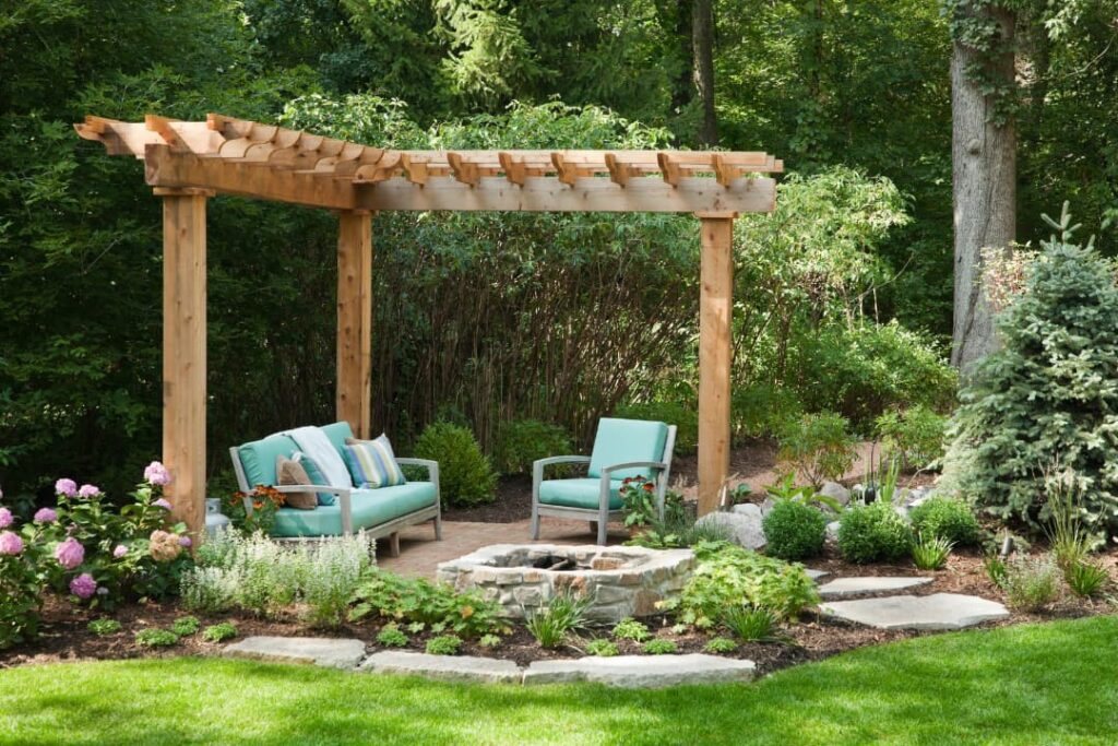Beautiful patio design in a landscape surrounded by nature with elements like furniture and enclosing wood support.