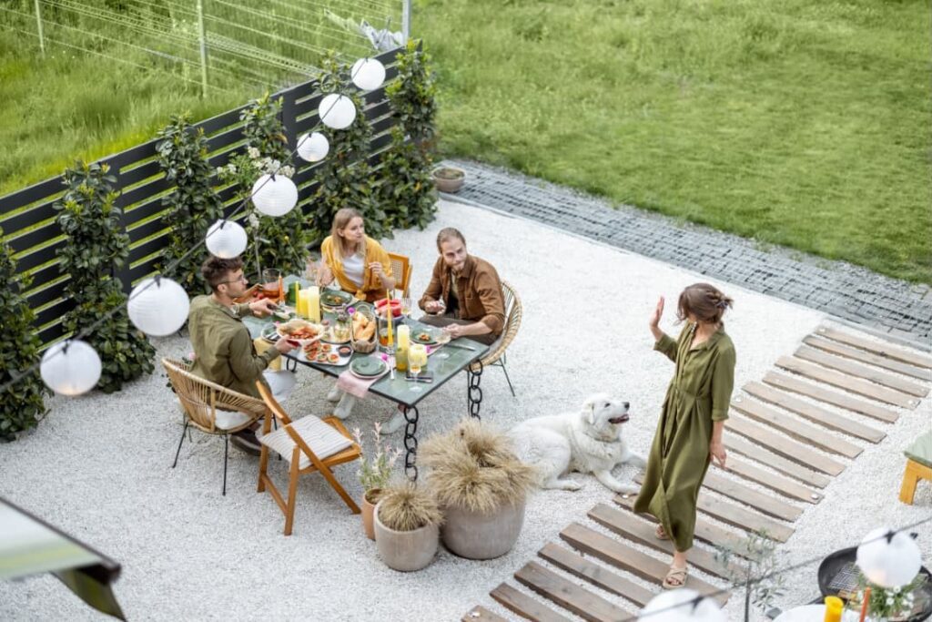 A group of family and friends with a pet dog enjoying their meal outdoors