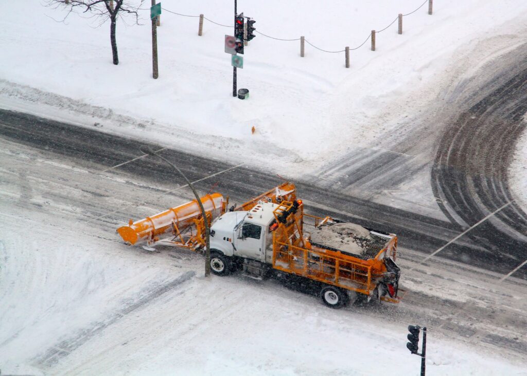 Large trucks equipped with plows push the snow to the sides, creating clear pathways.