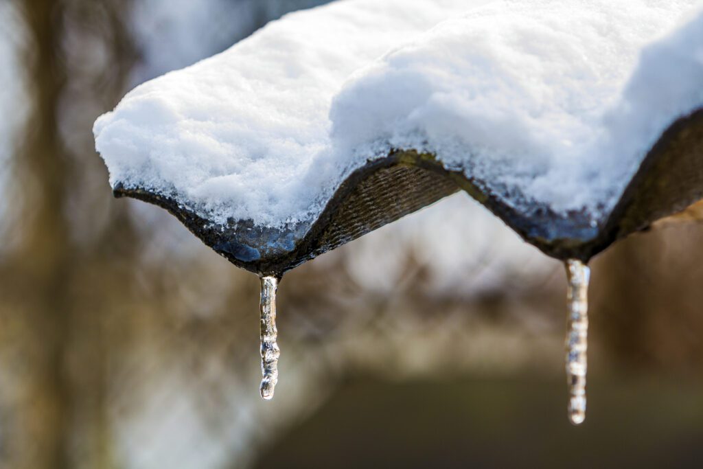 Winter icicles hanging from the roof close-up